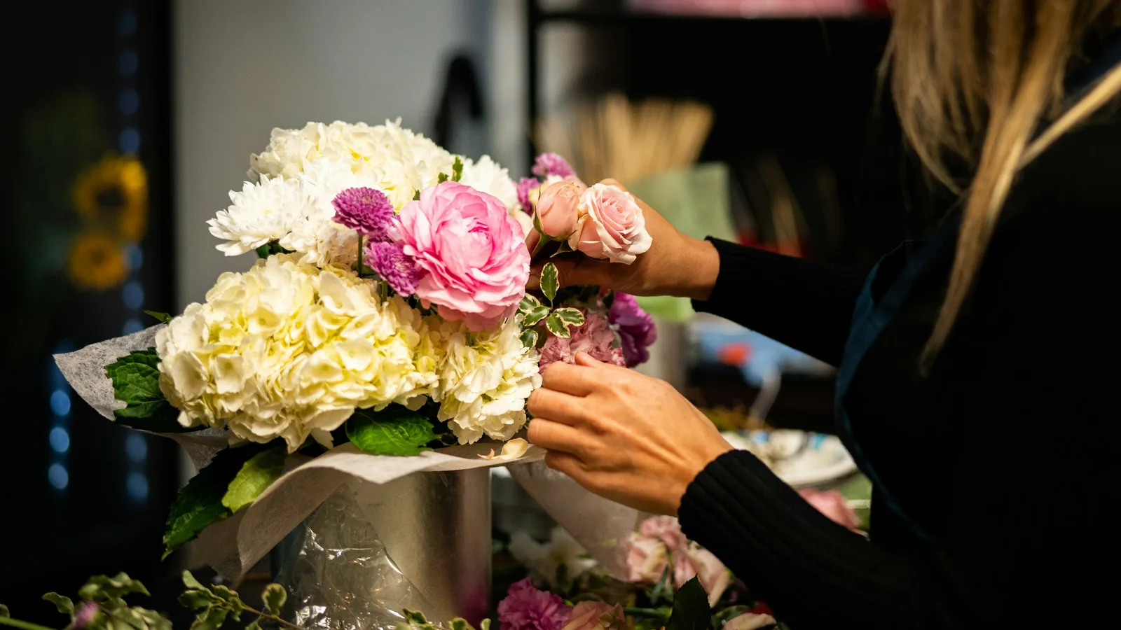 Florist som binder en bukett inför ett uppdrag